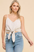 Load image into Gallery viewer, Dove Front Tie Cropped Tank Top in Natural. Features a flattering V-neckline, front tie detail, adjustable spaghetti straps, and a lightweight linen blend for a breezy, effortless look.