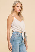 Load image into Gallery viewer, Side view of the Dove Front Tie Cropped Tank Top in Natural, showcasing the V-neckline, adjustable straps, and flattering cropped silhouette.