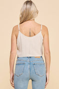 Load image into Gallery viewer, Back view of the Dove Front Tie Cropped Tank Top in Natural, showcasing a scooped back, adjustable straps, and flattering cropped silhouette.