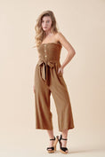 Load image into Gallery viewer, Shiloh Smocked Tube Top Jumpsuit in Camel. Featuring a strapless smocked bodice, self-tie waist, and wide-leg silhouette, crafted from a breathable cotton-linen blend for a relaxed yet polished look.