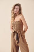 Load image into Gallery viewer, Close-up of the Shiloh jumpsuit’s smocked bodice, self-tie waist, and wood buttons, highlighting its texture and details.